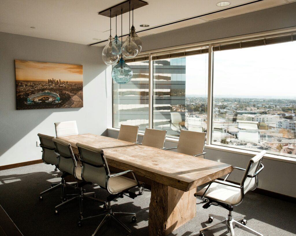 image of an empty boardroom or meeting room table in a modern office setting with a view out to an unknown city